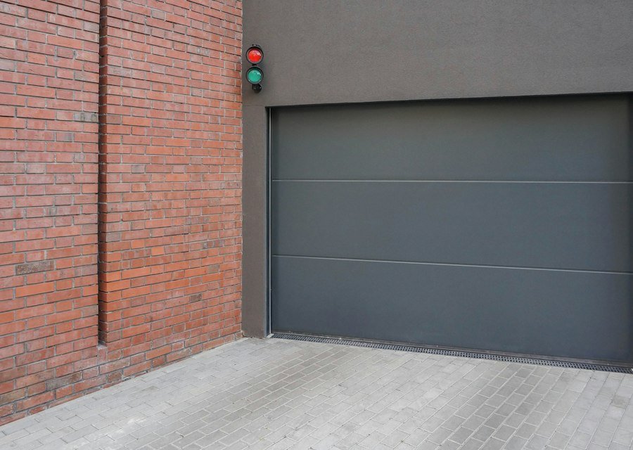 Grey garage door next to a brick wall