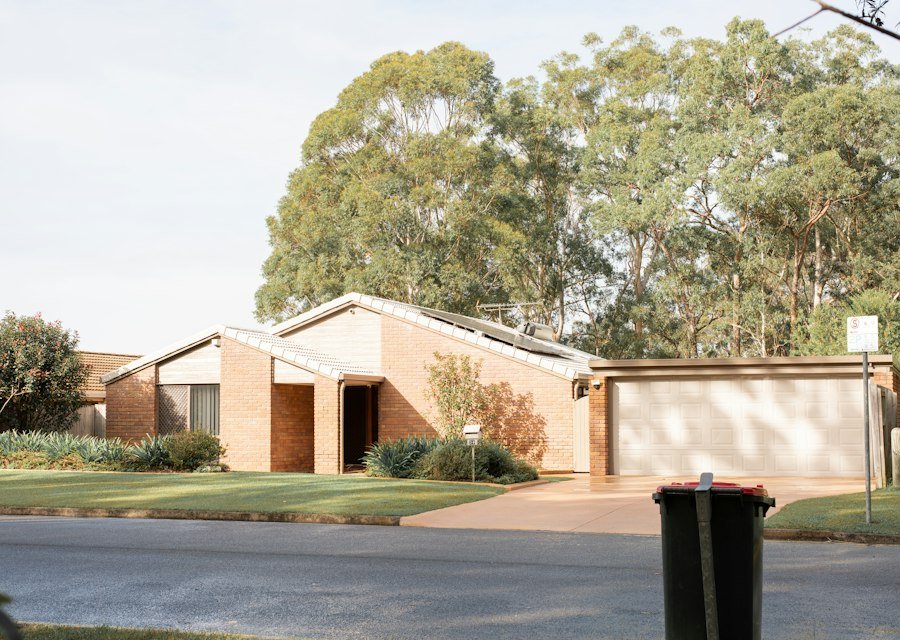 Modern brick house with a garage and green trees